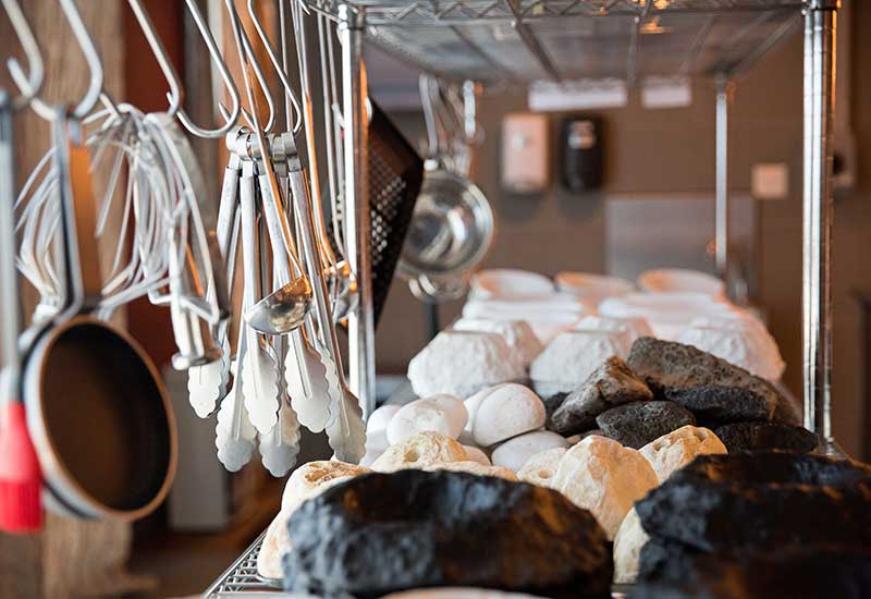 Serving dishes and implements are displayed on open shelves. Serving dishes and implements are displayed on open shelves.