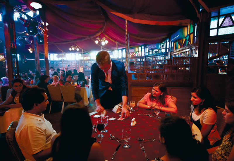 A roving magician entertains diners at Dubai Festival Centre's House of Illusions. A roving magician entertains diners at Dubai Festival Centre's House of Illusions.
