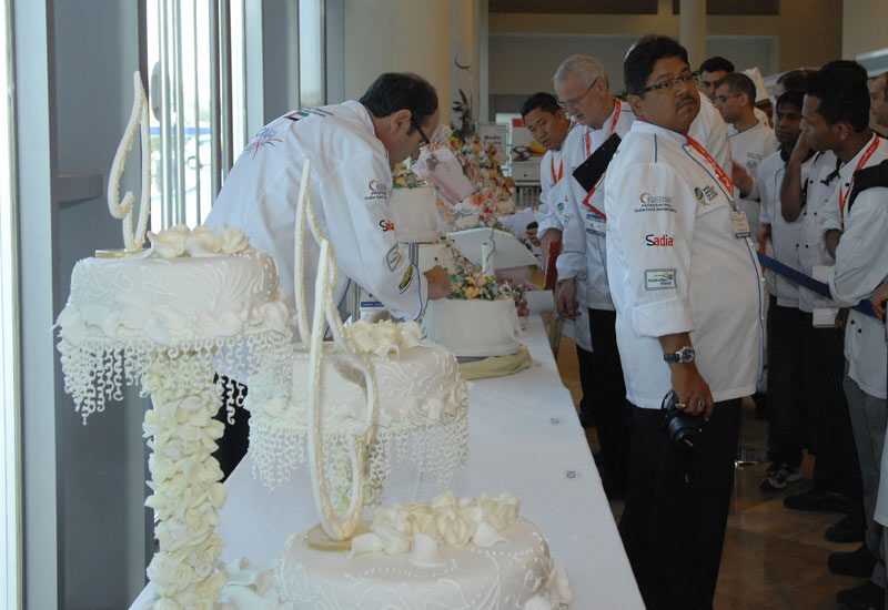 Judges studying the themed celebration cakes Judges studying the themed celebration cakes